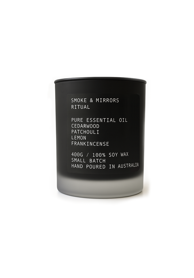 Black candle with white text on a white background