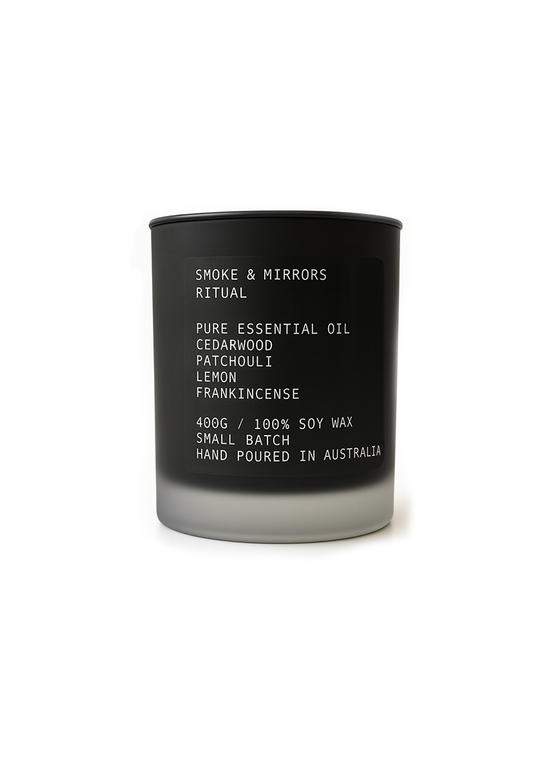 Black candle with white text on a white background